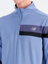 Buzo deportivo New Balance modelo Accelerate HZ, color azul, de manga larga con cuello alto y cierre frontal parcial. Cuenta con franjas horizontales en contraste en el pecho y el logo de la marca.