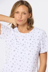 Blusa blanca con estampado floral negro, de corte recto y manga corta.
