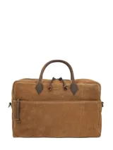 Maletín de suede marrón claro con asas cortas de cuero liso, bolsillo frontal con cierre y detalles metálicos en tono bronce.