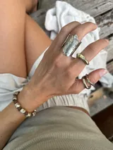 Anillo abierto de diseño rústico y orgánico, con textura irregular que evoca la naturaleza. Realizado artesanalmente en metal.