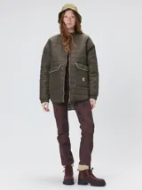 Campera reversible capitoneada con cierre frontal. Un lado es de color negro y el otro es de color beige, ambos con diseño acolchado. Cuenta con cuello redondo, mangas largas y bolsillos laterales.