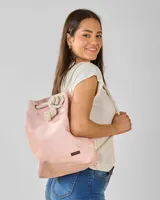 Mochila de tela color rosa con cordones de algodón crudo y etiqueta de cuero sintético marrón.