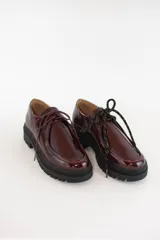 Zapatos tipo wallabee de cuero metalizado en tono peltre, con cordones negros y suela track de goma negra con plataforma.