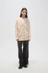 Saco de punto holgado con cuello en V y cierre frontal con botones, de manga larga y diseño clásico.