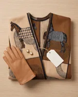 Poncho abierto en tonos marrón, beige y tostado, con diseño estampado de caballos y flecos en el ruedo.