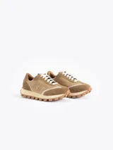 Zapatilla Mumi de cuero vacuno flor y descarne, color gris claro y celeste, con bordado "JCH" en el lateral. La base es de caucho para mayor liviandad y confort. Incluye cordón de algodón.