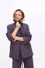 Blazer oversize a rayas color violeta oscuro, con solapa con volados y cordón para atar en la cintura.