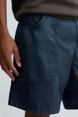 Bermuda de algodón color azul marino con efecto lavado, corte regular fit. Presenta bolsillos frontales de plastrón, bolsillo cerillero y bolsillo trasero de vivo. Cierre frontal con cremallera y botón.