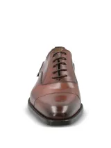Zapato de vestir tipo Oxford en cuero color marrón, con puntera reforzada y cierre mediante cordones. Presenta un diseño clásico con suela mixta de cuero y goma.
