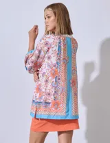 Blusa de gasa estampada con flores, cuello redondo y abertura central con botones. Manga ¾ con puño elastizado.