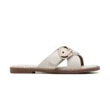 Sandalia plana de estilo casual con tiras cruzadas en el empeine, confeccionada en material sintético color beige. Presenta una hebilla metálica decorativa en tono dorado y suela plana con detalle de costura perimetral.