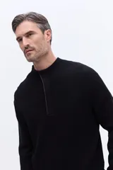 Buzo de tejido acanalado con cuello alto y apertura frontal con cierre, de calce cómodo y estructura limpia.