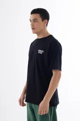 Remera negra de algodón con cuello redondo y mangas cortas. Estampado en la espalda con personajes de dibujos animados sosteniendo fajos de billetes y texto "VERNAL CLUB HORRIBLPARTY".