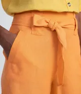 Short de tiro alto confeccionado en mezcla de viscosa y lino en color naranja. Presenta una cintura con pasadores anchos, lazo de ajuste del mismo tejido y bolsillos laterales.