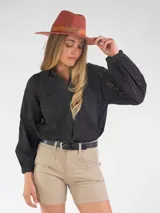 Blusa negra de broderie, con mangas largas abullonadas y cierre frontal de botones.