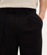 Pantalón de corte wide leg con diseño de sastrería, confeccionado en tejido estructurado con frisos frontales, bolsillos laterales y cierre invisible.