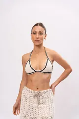 Top de bikini tejido a crochet color crudo, con terminaciones en negro y forro interior.