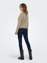 Cardigan de punto color beige melange, con cuello redondo, cierre frontal de botones y detalle de volados en el ruedo y los puños.