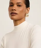 Blusa de corte regular confeccionada en tejido de rib acanalado color naranja. Presenta cuello alto y mangas cortas.