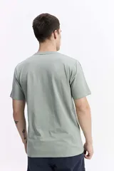 Remera de manga corta color marrón oscuro, con escote redondo y fit regular. Presenta un estampado frontal con texto en color amarillo y blanco.