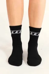 Medias Billabong Boot color negro, con diseño de olas blancas en la parte superior del caño.