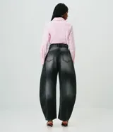 Pantalón barrel de jean color negro con lavado desteñido, cintura alta con trabillas, cierre frontal de botón y cremallera, bolsillos funcionales y corte amplio con ruedo ajustado.