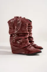 Bota texana de cuero color bordó, con caña arrugada y detalle de cadena con aros metálicos.