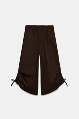 Pantalón culotte marrón de tiro medio con cintura elástica, bolsillos laterales ocultos y bajo con cordones ajustables para fruncir.