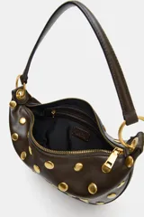 Bolso tipo hobo color marrón oscuro con tachas doradas distribuidas por todo el cuerpo. Cuenta con un asa de hombro y dos anillas metálicas doradas. El cierre es de cremallera metálica y tiene un bolsillo interior con cremallera.
