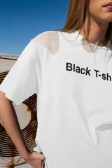 Remera blanca de algodón de corte relajado con estampado "Black T-shirt" en el frente y detalles de malla en los hombros.