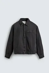 Cazadora de denim acolchada en color negro con efecto lavado. Presenta un corte boxy fit, cuello solapa, cierre frontal con cremallera, bolsillo con cierre en el pecho y bajo elástico.