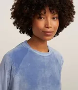 Pijama largo de dos piezas confeccionado en plush, compuesto por una blusa de manga larga con cuello redondo y un pantalón con cintura elástica y puños ajustados en los tobillos.