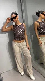 Pantalon de tiro bajo con cordón ajustable en la cintura, confeccionado en tela brillante con textura acanalada, de corte recto y holgado.