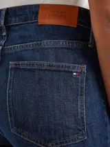 Jean Tommy Hilfiger de corte bootcut y talle medio, confeccionado en tejido denim elástico. Presenta un diseño clásico de cinco bolsillos con cierre de cremallera y botón.