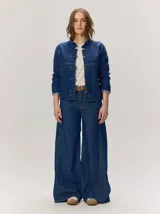 Pantalon de jean azul de corte ancho y relajado, con tiro alto y costuras decorativas verticales.