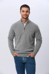 Buzo de tejido de punto color azul marino, con cuello alto y cierre frontal parcial. Presenta puños y ruedo acanalados, con un pequeño detalle bordado en el pecho.