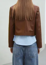 Chaqueta de cuero de ovino en color marrón, de diseño corto y cruzado, con doble botonadura frontal y solapas clásicas.