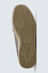Zapatilla de estilo retro con diseño de paneles en cuero y serraje, cordones en tono crudo y suela de goma a contraste.