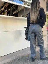 Pantalón gris de cuero sintético con corte recto y tiro alto.