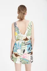 Mono corto con estampado de hojas, flores y tigres en tonos celeste, verde, amarillo y negro. Tiene escote en V, cintura elastizada con cordón y bolsillos laterales.
