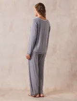 Conjunto de pijama marca René Rofé, compuesto por pantalón y remera a rayas grises y blancas. La remera es de escote en V, con bolsillo en el pecho y mangas largas. El pantalón tiene cintura elastizada y bolsillos laterales.