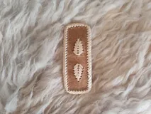 Broche para pelo artesanal de cuero con bordados en tiento fino.