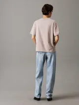 Remera de corte holgado confeccionada en algodón, con cuello redondo y mangas cortas. Presenta el logo de Calvin Klein Jeans bordado en relieve en el centro del pecho.