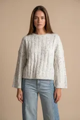 Sweater de punto con textura de ochos, color gris melange con motas oscuras, cuello redondo y mangas largas con terminación acampanada.