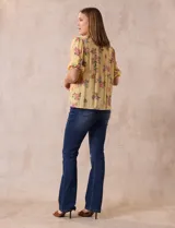 Blusa de gasa estampada con cuello a la base, escote en V plisado y lazo de ajuste. Delantera con detalles en puntilla y manga corta con puño fruncido.