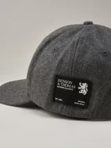 Gorra de béisbol de paño en color azul marino, con etiqueta lateral con logo de la marca.