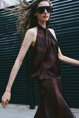 Top halter estampado de color bordó, con cuello alto, diseño sin mangas y cierre posterior con abertura y botón.