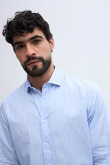 Camisa de manga larga fit semi slim color celeste, con cierre frontal de botones y cuello camisero clásico.