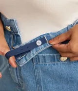 Bermuda de jeans de algodón, color azul medio, de corte amplio y largo hasta la rodilla. Presenta tiro alto con ajuste elástico interno en la cintura y bolsillos frontales.