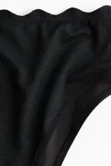 Vedetina de bikini tiro alto color negro, con borde superior festoneado y diseño completamente forrado.